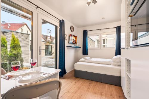 a bedroom with a bed and a table with wine glasses at Holiday&Stay, Tiny living in Fronreute