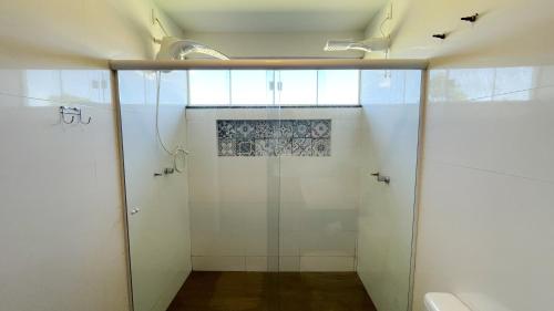 a bathroom with a shower with a glass door at Mirante do Morro in Alto Paraíso de Goiás