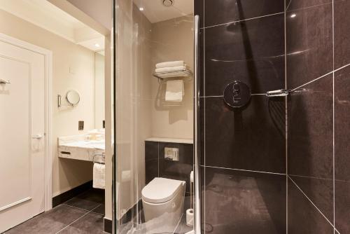 a bathroom with a shower with a toilet and a sink at Coldra Court Hotel by Celtic Manor in Newport