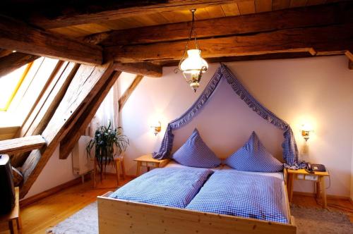 a bedroom with a blue bed in a attic at Landhaus Zum Falken in Tauberzell