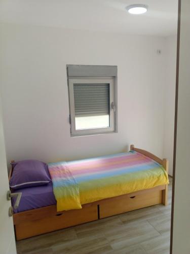 a bed in a room with a window at Vila Komfor in Jajinci