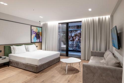a hotel room with a bed and a couch at Boe Luxury Hotel in Sarandë