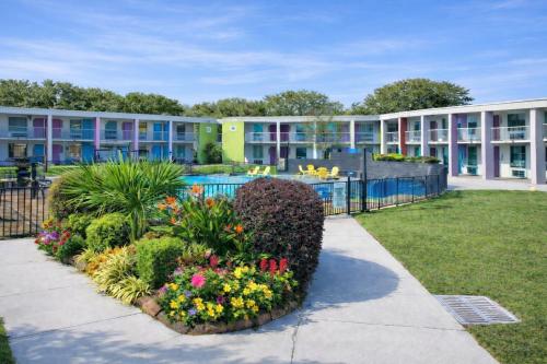 a building with a courtyard with a pool and flowers at Rest and Relax Inn in Pensacola