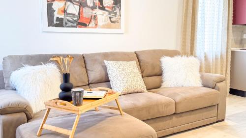 a living room with a brown couch and a table at Imperial Golden Suite by Ca-Sa Check in Chioggia
