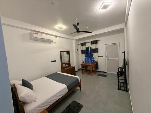 a bedroom with a bed and a ceiling fan at Diving Nest in Trincomalee