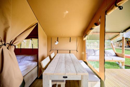 a tent with a table and a bed in it at Glamping Elba in SantʼAnna