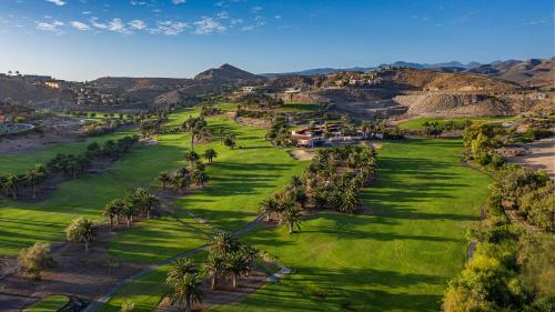 an aerial view of a golf course with palm trees at Salobre Hotel Resort & Serenity in Salobre