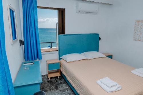 a bedroom with a bed with a view of the ocean at San Georgio Hotel in Tsoutsouros