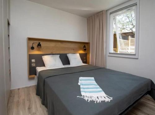a bedroom with a large bed with a window at Camping Mas De Pierredon in Sanary-sur-Mer