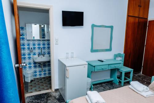 a small bathroom with a sink and a mirror at San Georgio Hotel in Tsoutsouros