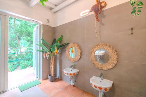 a bathroom with two sinks and mirrors on the wall at Glamping Elba in SantʼAnna