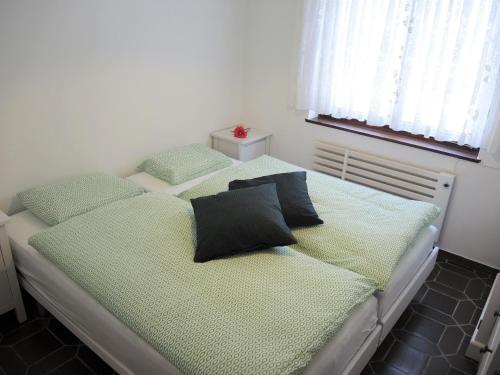 a bed with two pillows on it in a bedroom at Casa Hella by fewotessin in Lavertezzo