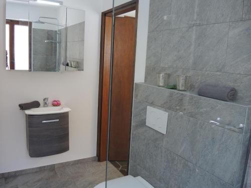 a bathroom with a shower and a toilet and a sink at Casa Hella by fewotessin in Lavertezzo