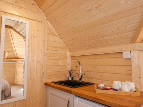 a kitchen with a sink in a wooden cabin at Little Luxe Lodges 1 in Kyle of Lochalsh