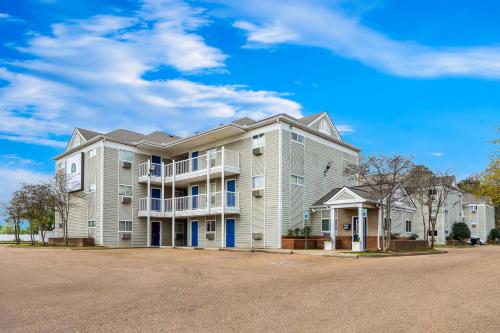 a large apartment building with a blue sky in the background at Birch Hill Suites Jackson in Jackson