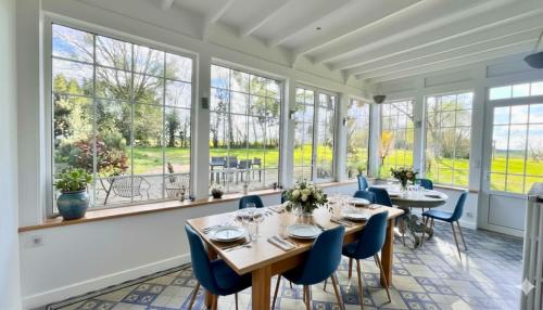a dining room with tables and chairs and windows at Domaine de Treuillaud in Villers-les-Ormes
