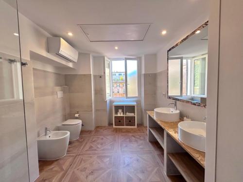 a bathroom with two sinks and two toilets at Vicolo Doria Apartment in Rome