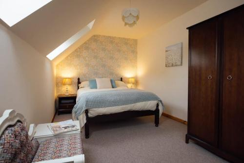 a bedroom with a king sized bed in a attic at Granary Cottage at Scolton Cottages - Indoor pool in HAW