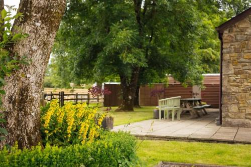 a park with a bench and trees and flowers at Granary Cottage at Scolton Cottages - Indoor pool in HAW