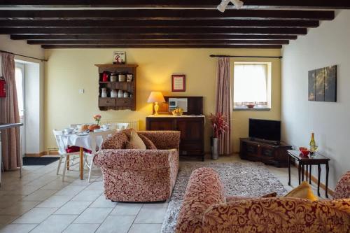 a living room with a table and couches and a dining room at Granary Cottage at Scolton Cottages - Indoor pool in HAW