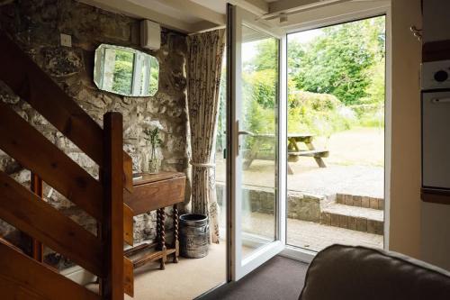a sliding glass door leading to a patio at Dairy Cottage at Scolton Cottages - Indoor pool in Haverfordwest
