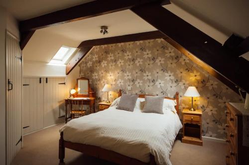 a bedroom with a large bed and a wall at Dairy Cottage at Scolton Cottages - Indoor pool in Haverfordwest