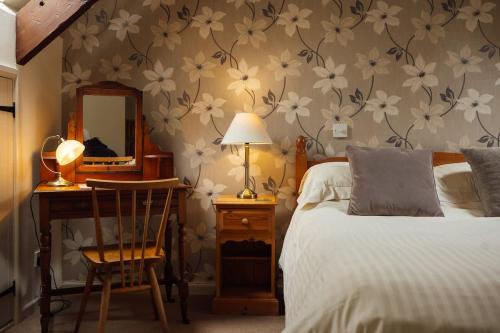 a bedroom with a bed and a desk and a mirror at Dairy Cottage at Scolton Cottages - Indoor pool in Haverfordwest