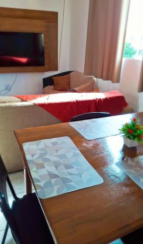 a room with a table and a couch and a bed at Praticidade e conforto á poucos passos do aereoporto in Várzea Grande