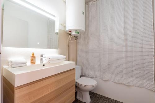 a bathroom with a white sink and a toilet at La Pomponnette du Bassin in Arcachon