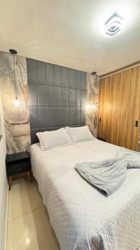 a bedroom with a large bed with white sheets at Loft Completo Compact in Palmas
