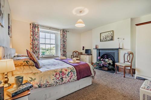 a bedroom with a bed and a fireplace at 3 Bed in Uphill oc-n27747 in Linkinhorne