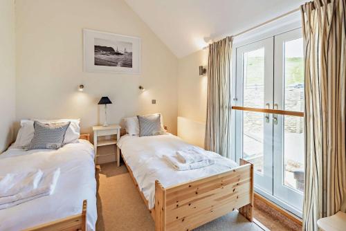 two beds in a room with a window at 2 Bed in Croyde oc-r27591 in Croyde