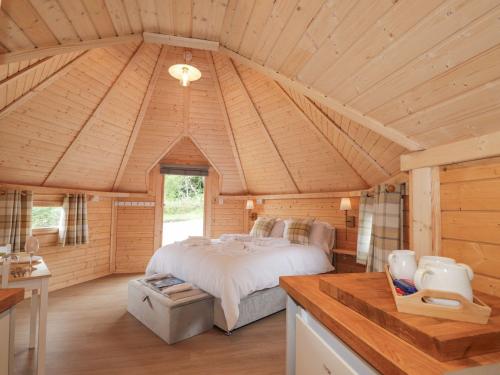 a bedroom with a bed in a wooden cabin at Little Luxe Lodges 2 in Balmacara
