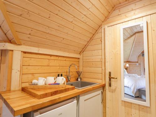 a kitchen with a sink in a wooden cabin at Little Luxe Lodges 2 in Balmacara
