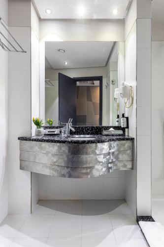 a bathroom with a large sink and a mirror at Nobel Zira Hotel in Belgrade