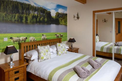 a bedroom with two beds and a painting of sheep at 9 Bed in Brecon oc-cvelo in Cray