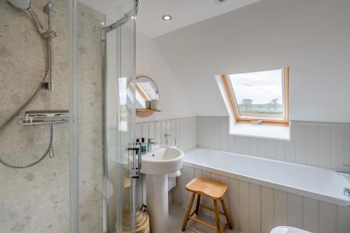 a bathroom with a tub and a sink and a shower at 4 Bed in Alyth oc-e31853 in Bridgend of Lintrathen