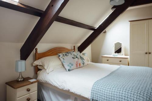 a bedroom with a white bed with a wooden headboard at Beech Cottage - Spacious Cottage with Pool Near Coastal Trails in HAW