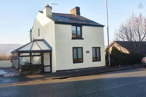 a white house on the side of a street at 103 Whalley Road Ramsbottom in Ramsbottom