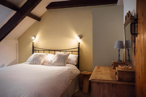 a bedroom with a large bed and a table at Barn Cottage - Family-Friendly Cottage with Heated Indoor Pool in Haverfordwest