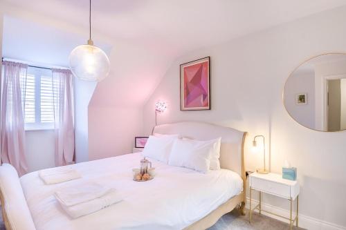 a white bedroom with a white bed and a mirror at 3 Bed in Framlingham oc-m32532 in Framlingham