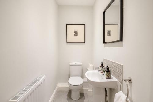 a white bathroom with a toilet and a sink at 3 Bed in Framlingham oc-m32532 in Framlingham