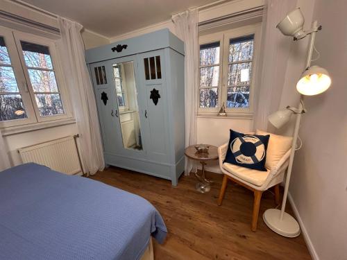 a bedroom with a bed and a chair and a lamp at Achtern Diek Haus 12d Wohnung 1 PALSTEK in Müggenburg