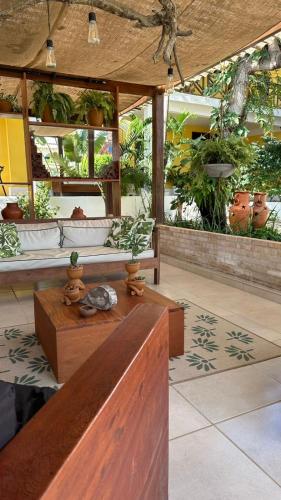 a lobby with a wooden bench and plants at Villa Biju in Jericoacoara