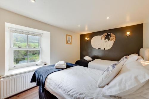 a bedroom with two beds and a sheep on the wall at 5 Bed in Muker oc-ds1056 in Muker