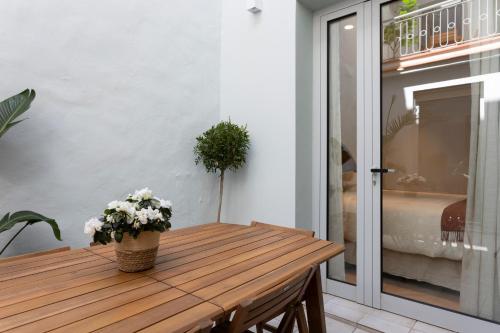 a wooden table with flowers on it in a room at Apartamentos Boutique Casco Histórico in Las Lagunas