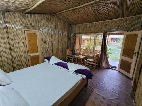 a bedroom with a bed and a table and a window at The Sylvan Hut in Leh