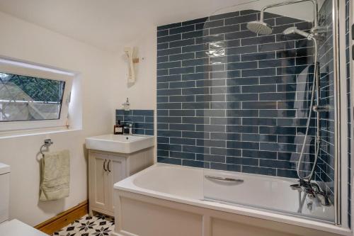 a bathroom with a blue tiled wall next to a shower at 2 Bed in Mumbles oc-v30980 in The Mumbles