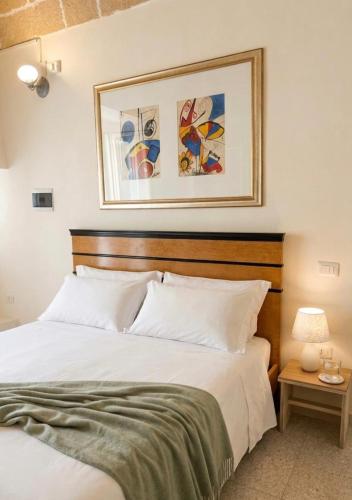 a bedroom with a bed with a picture on the wall at Gallipoli - Suite Levante in Gallipoli