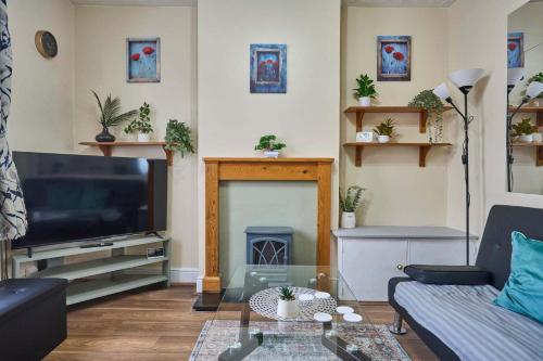 a living room with a television and a fire place at Host & Stay - Dover Retreat in Ipswich
